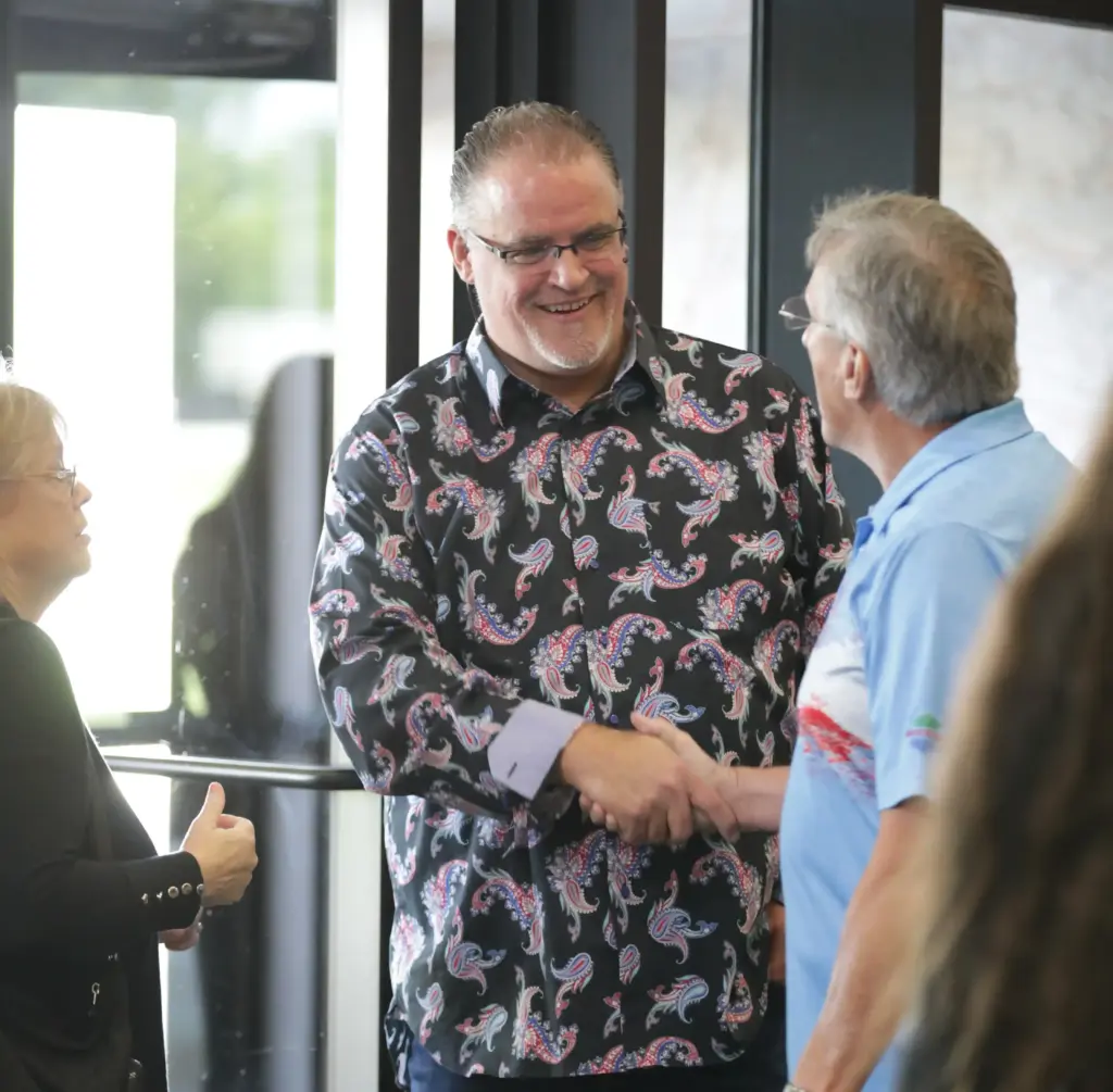 Pastor Craig Hagin greeting people at Rhema Bible Church door.