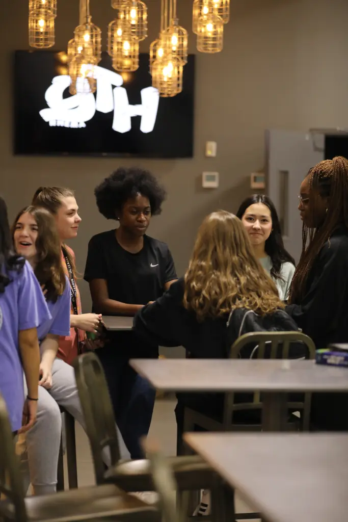 Four youth girls gathering around the table at the MAC build